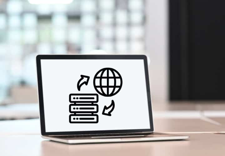 Laptop on a desk with a graphic on the screen representing website hosting